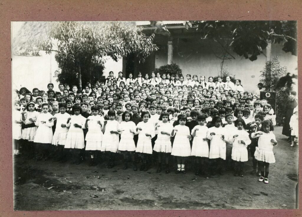 Fiesta del cepillo dental de las alumnas de la escuela anexa a la Escuela Normal de Preceptoras nº 1. Año 1916. El evento se celebra en las escuelas de Santiago una vez al año con apoyo de sociedades odontológicas y de particulares, con el fin de estimular el cuidado de la dentadura y la higiene bucal. Fotografía en blanco y negro de niños y niñas con cepillos de dientes en las manos (Copyright: Departamento de Extensión Cultural del Ministerio de Educación y Sección de decorado y proyecciones escolares. Disponible en: http://repositorio.cultura.gob.cl/handle/123456789/5457).